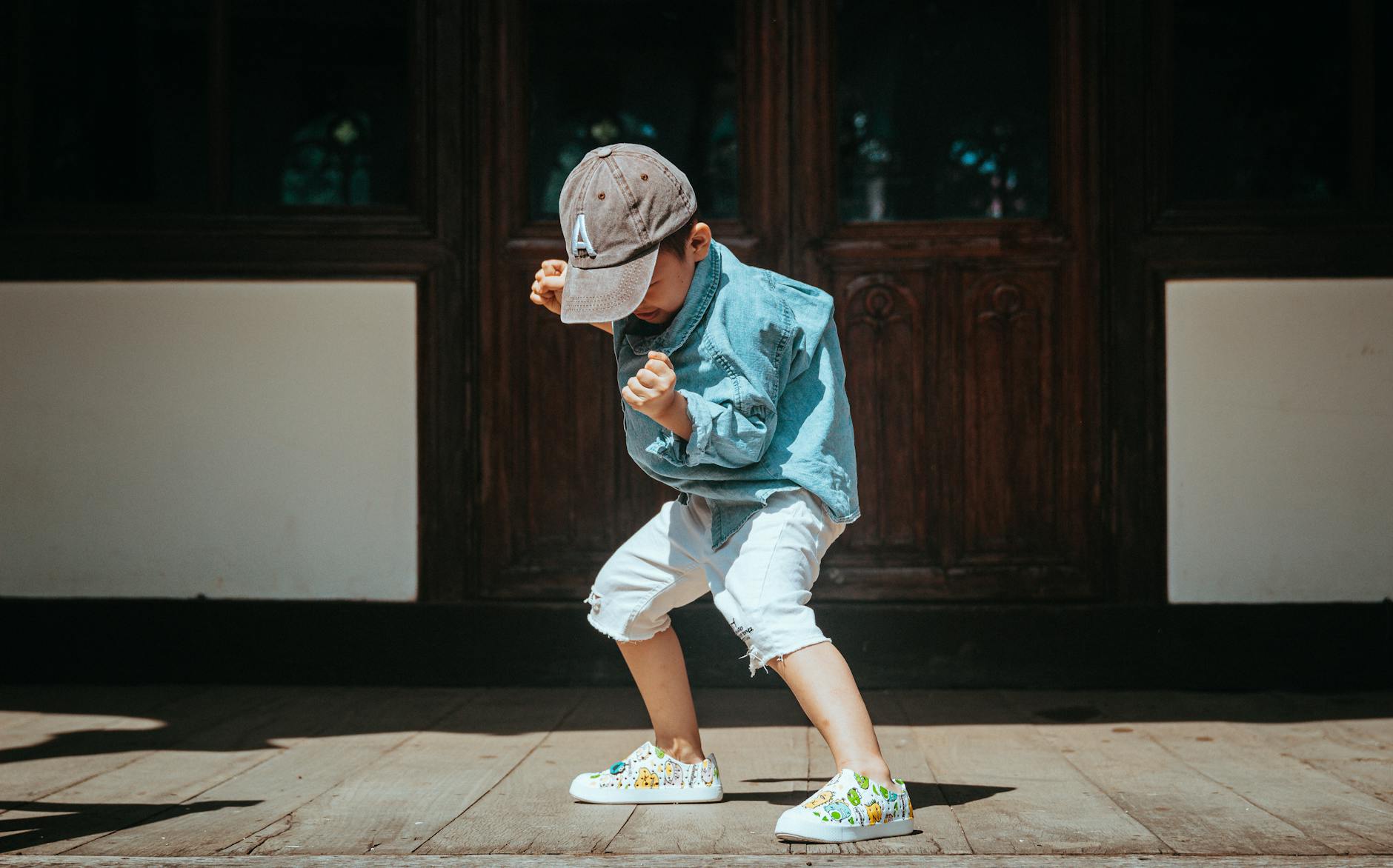 playful child in denim outfit dancing outdoors